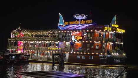 Un-Colorido-Barco-Restaurante-Flotante,-Iluminado-Por-Coloridas-Luces-LED-En-El-Río-Por-La-Noche