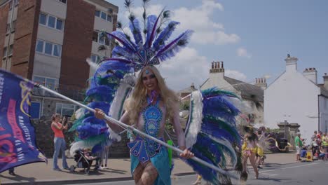 Woman-in-peacock-costume-waves-flag-and-dances-in-parade-at-Pride-festival-on-the-Isle-of-White-2018