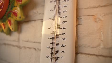 Thermometer-An-Einem-Heißen-Wintertag-Mit-Sonnenlicht,-Das-Auf-Die-Gartenmauer-Trifft