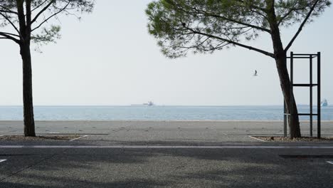 Menschen-Auf-Elektro--Und-Normalen-Fahrrädern,-Die-An-Der-Strandpromenade-Von-Thessaloniki-Vorbeifahren,-Meereshintergrund,-Sonniger-Sommertag