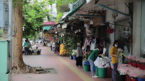 People-Shopping-at-Flower-Market-in-Sanam-Chai,-Bangkok-Along-Sidewalk