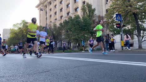 Medium-view-of-marathon-runners-competing-and-racing-in-classic-city-center