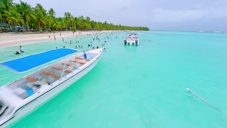 Vista-Aérea-De-Turistas-Bañándose-Y-Disfrutando-De-Vacaciones-En-Aguas-Turquesas-Del-Mar-De-La-Isla-Saona,-República-Dominicana