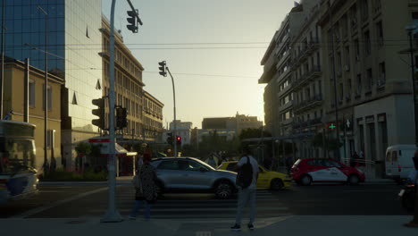 Belebtes-Stadtbild-In-Athen-Mit-Fußgängern-Und-Motorrollern,-Die-Bei-Sonnenuntergang-Durch-Die-Straßen-Navigieren