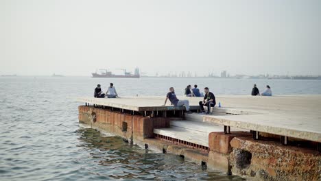Junge-Leute-Sitzen-Entspannt-Am-Meer,-Thessaloniki,-Neue-Promenade,-Sommertag