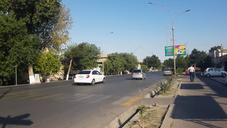 City-Street-Traffic-in-Kokand,-Uzbekistan-on-Hot-Sunny-Day,-Shops,-People-and-Cars,-Panorama