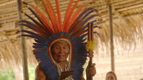 El-Chamán-De-La-Tribu-Amazónica-Proporciona-Bendición-Espiritual-En-Traje-De-Tocado-De-Plumas-De-Guacamayo,-Ceremonia-De-Medicina-Indígena,-Manaos-Amazónicos,-Brasil.