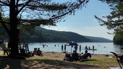 Sonnenanbeter-Und-Schwimmer-An-Einem-Sonnigen-Tag-Am-Meech-Lake,-Quebec,-Kanada