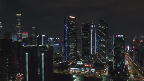 Distrito-De-Edificios-De-Oficinas-Del-Centro-Iluminado-De-Guangzhou-Con-Un-Nuevo-Sitio-De-Construcción-En-Primer-Plano-Por-La-Noche
