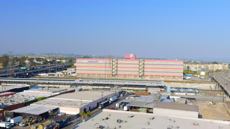 Aerial-view-rising-over-Dependable-logistics-warehouse-to-reveal-downtown-Los-Angeles-California-cityscape