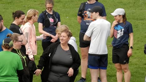 Eine-Gruppe-Von-Läufern-Versammelte-Sich-Zu-Beginn-Ihres-Fitnesslaufs-Im-örtlichen-Park,-Unterhielt-Sich-Und-Unterstützte-Sich-Gegenseitig