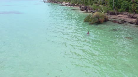Drone-orbit-view-of-girl-swim-at-Zapatilla-Cay-beach-in-Bocas-del-Toro,-Panama_4K