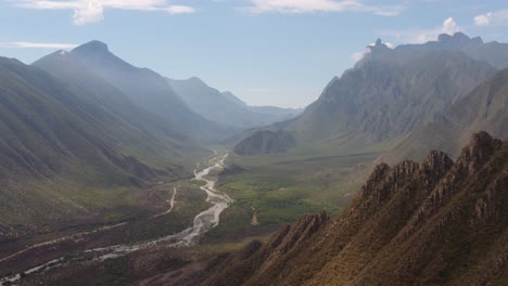 Atemberaubende,-Weite-Luftaufnahme-Des-Flusses,-Der-Durch-Ein-Von-Steilen-Klippen-Und-Bergen-Gesäumtes-Tal-In-Der-Nähe-Von-Monterrey,-Mexiko-Und-Dem-La-Huasteca-Park-Fließt
