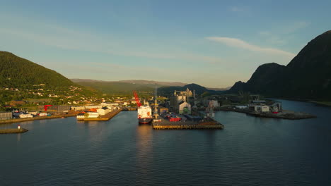 Aerial-view-of-ship-docking-at-industrial-park-in-Mosjoen,-Norway