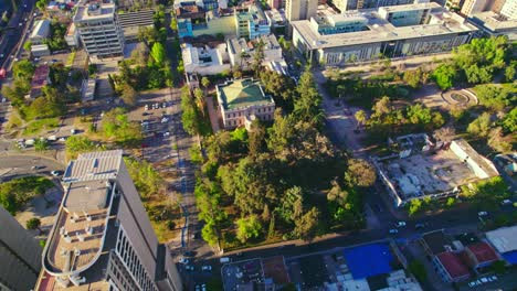 Drone-flyover-Skyscrapers-toward-Cousino-Palace-Museum-Surrounded-by-Lush-vegetation,-Santiago,-Chile
