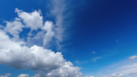 Fluffy-white-cumulus-clouds-float-across-bright-blue-sky,-nature-scene