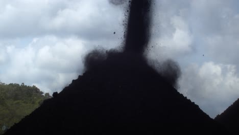 Zeitlupe-Zerkleinerter-Kohle-Fällt-In-Haufen-Mit-Dramatischer-Wolke-Im-Hintergrund