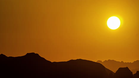 Goldener-Sonnenaufgang-über-Der-Silhouette-Zerklüfteten-Berggeländes---Zeitraffer