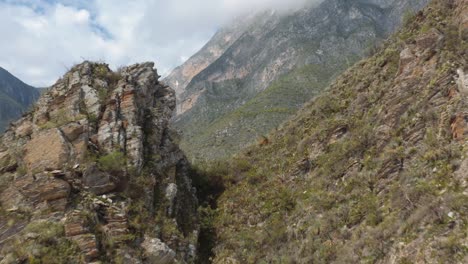 Drone-flying-through-mountain-gap-gives-wide-view-of-steep-valley-and-rugged-terrain-of-Nuevo-Leon,-Mexico-near-Monterrey