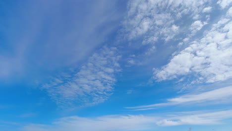 Wispy-clouds-roll-across-pale-blue-sky-in-spacious-nature-background
