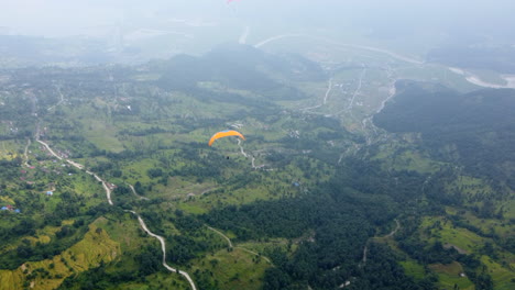 Gleitschirm-Fliegt-über-Nebliger-Grüner-Landschaft-In-Der-Nähe-Von-Pokhara-In-Nepal