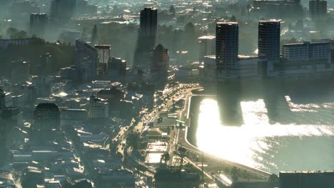 Aerial-View-Over-Downtown-Puerto-Montt-City-With-Morning-Mist-And-Sunshine