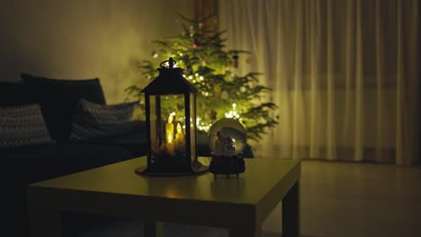 Eine-Kerzenlaterne-Und-Eine-Schneekugel-In-Der-Nähe-Des-Funkelnden-Weihnachtsbaums-–-Statische-Aufnahme