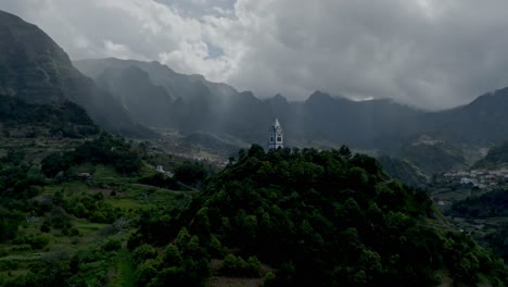 Licht-Durchdringt-Dicke-Graue-Wolken,-Während-Die-Turmkirche-Madeira,-Portugal,-überblickt