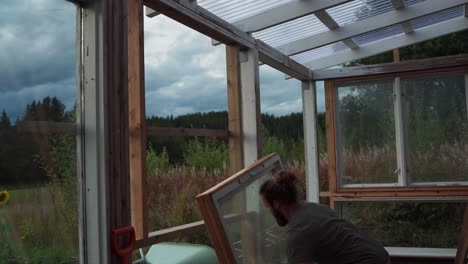 Mann,-Der-Das-Glasfenster-Mit-Holzrahmen-Installiert