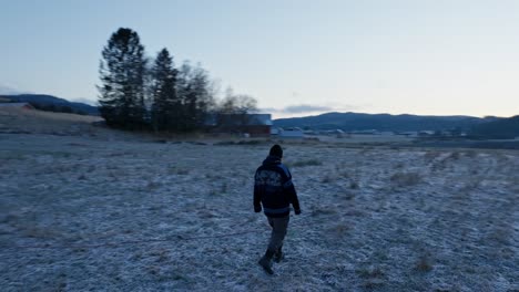 European-Man-Walking-On-Field-With-Alaskan-Malamute-Dog-In-Indre-Fosen,-Norway