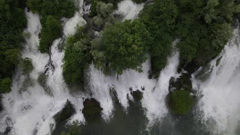 Aerial-view-of-Kravica-Waterfalls-,-Bosnia-and-Herzegovina,-waterfall-flowing-through-trees