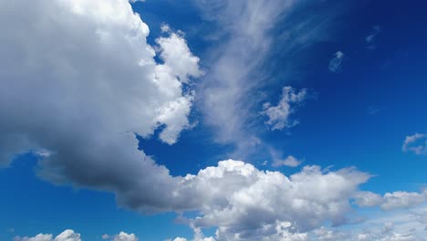 Sky-time-lapse-as-clouds-rush-through-vivid-dark-blue-sky,-nature-shot