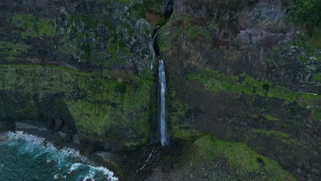 Epic-coastal-waterfall-cascades-hundreds-of-feet-down-into-open-ocean,-Madeira-Portugal