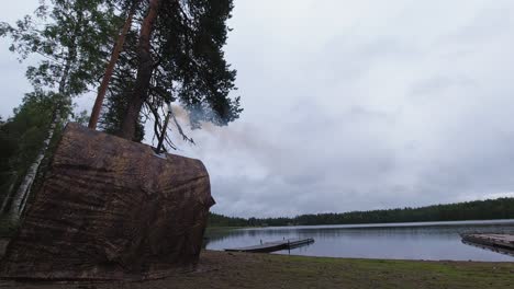 Timelapse:-camo-wall-sauna-tent-with-smoking-stove-pipe-beside-boreal-lake
