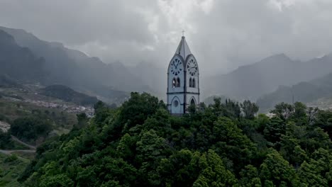 Dramatische-Lichtstrahlen-Zwischen-Wolken-Umrahmen-Den-Kirchturm-Auf-Madeira,-Portugal