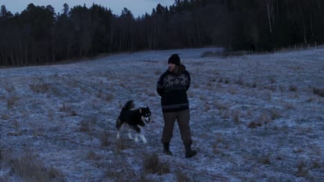 Indre-Fosen,-Trondelag-County,-Norway---A-Man-Walks-His-Dog-on-the-Farm-in-November---Tracking-Shot