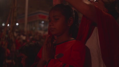In-darkness-young-teenage-female-prays-and-shows-her-religious-devotion