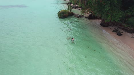 Drone-view-of-girl-swim-at-Zapatilla-Cay-beach-in-Bocas-del-Toro,-Panama_4K