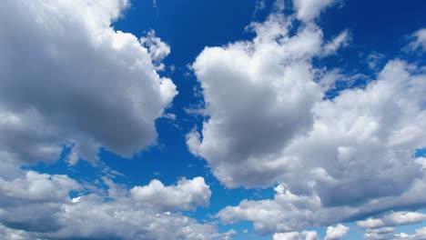 Puffy-clouds-roll-across-blue-sky,-full-frame-nature-background
