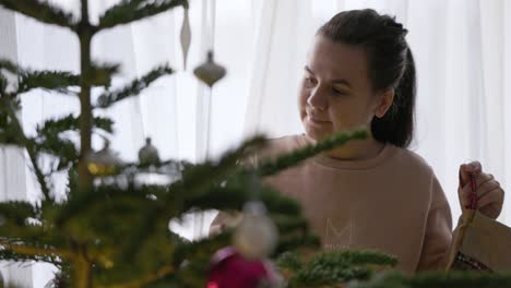 Ein-Mädchen-Legt-Weihnachtssocken-Auf-Den-Baum-–-Mittlere-Nahaufnahme