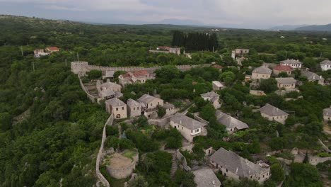 Drohnenansicht-Der-Hoch-über-Dem-Flussufer-Erbauten-Festungsstadt-Pocitelj,-Ansicht-Der-In-Bosnien-Erbauten-Burg