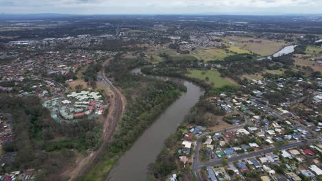 Volando-Sobre-El-Río-Logan-Y-Los-Suburbios-Frente-Al-Río-En-Queensland,-Australia
