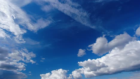 Stratas-of-clouds-float-across-vivid-blue-sky,-nature-background