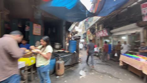 POV-shot-of-locals-walking-around-narrow-alley-of-old-Kolkata,-India-at-daytime