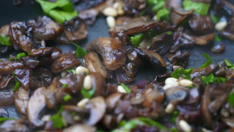 Mushrooms-frying-in-a-pan-with-pine-nuts-and-parsley