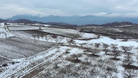 Aerial-mountain-snow-covered-agriculture-fields-Mountains-peaks-background-cloudy
