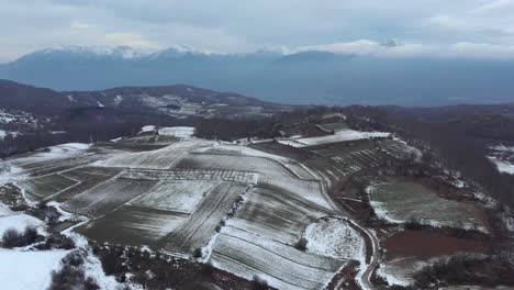 Luftaufnahmen-über-Schneebedeckten-Bergebenen-Im-Winter,-Nebliger,-Launischer-Tag,-Bewölkter-Winter