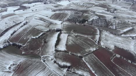 Drone-Bird’s-eye-view-of-winter-snowy-mountain-agriculture-fields-day