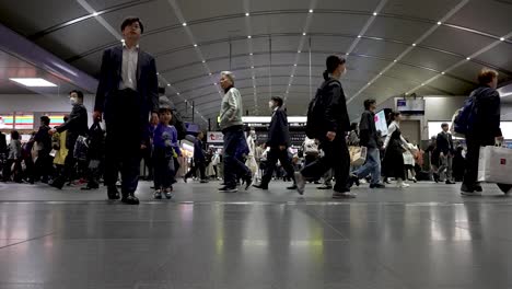 Gente-Caminando-En-La-Estación-De-Tren-Cubierta-Hacia-Su-Plataforma-En-Kioto