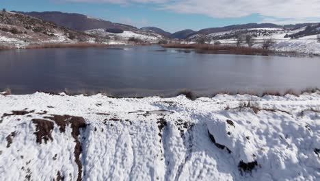 Antena-Sobre-Lago-Congelado-De-Montaña-Con-Hielo-De-Nieve-Día-Soleado-Cielo-Azul